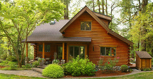 A log cabin with a porch and a garden.
